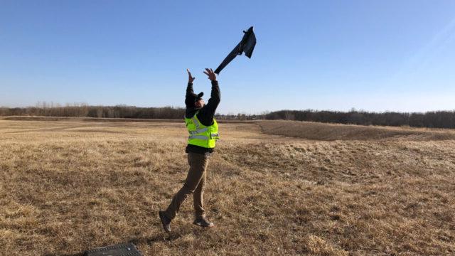 A field technician operating a drone over a landfill