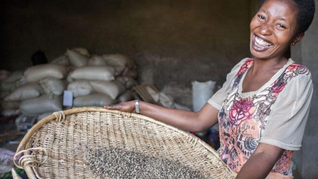 Woman holds a basket of dried coffee beans in DRC