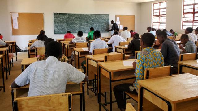 Students sitting at desks facing chalk board in a classroom in Malawi