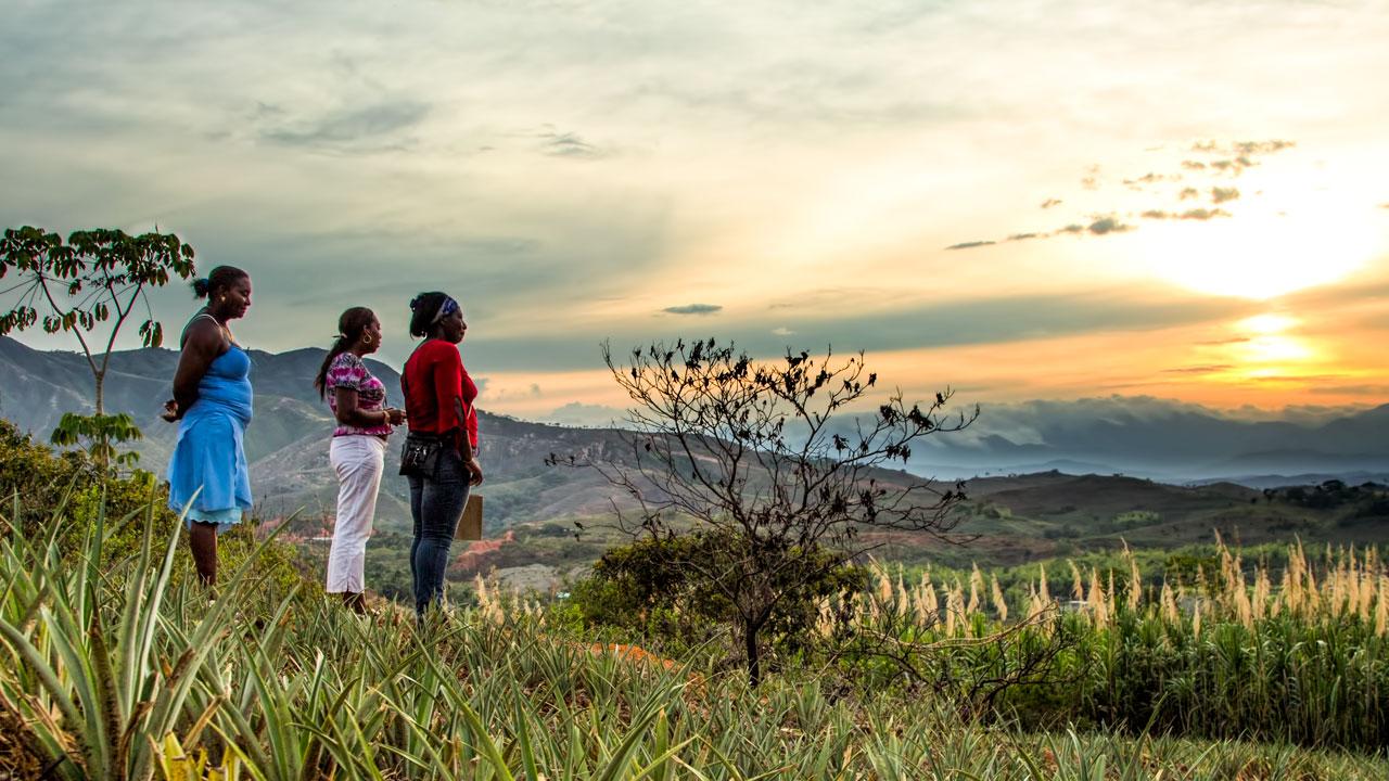 Three women look out on a landscape in Colombia
