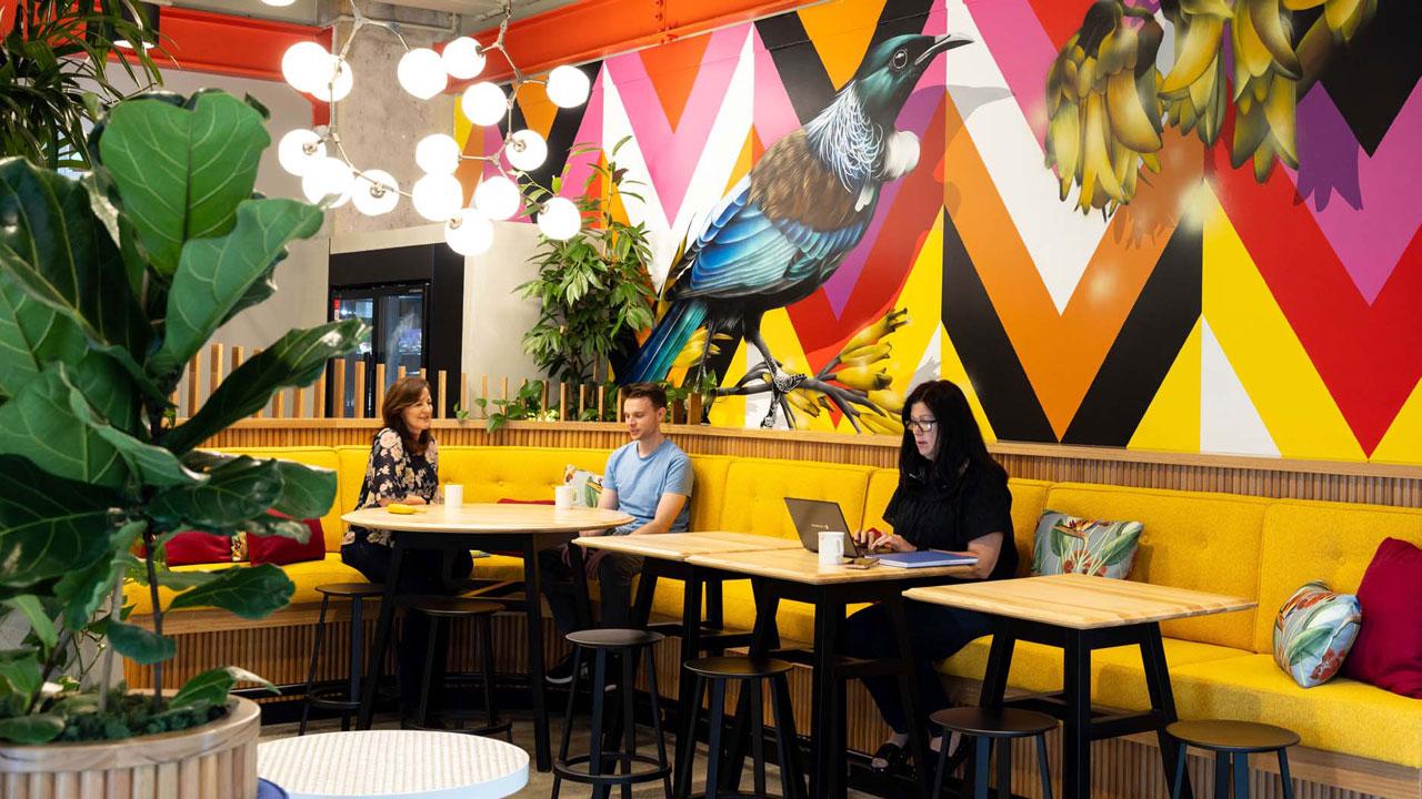 三个全球最大体育平台坐在咖啡厅式的办公空间里，身后的墙上挂着五颜六色的鸟和花的艺术品