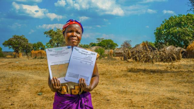 A Zambian woman holds her legal property documents as a result of TGCC project interventions