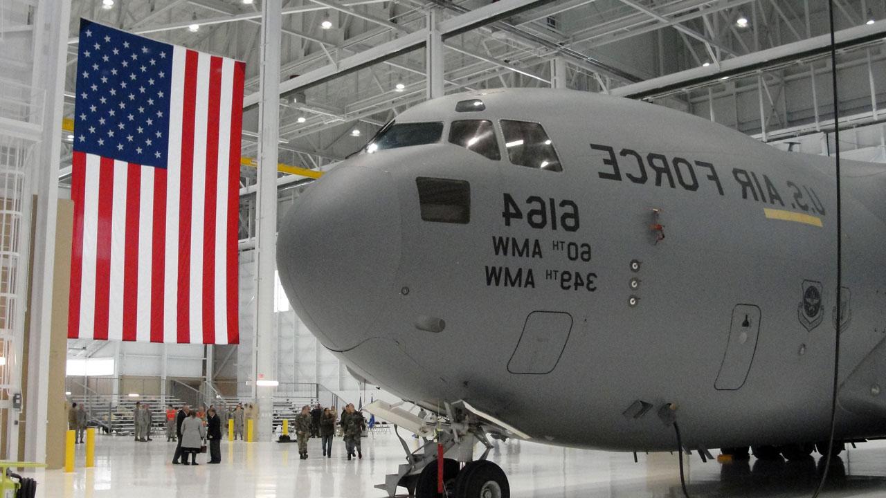库中的KC-10先进加油机和货机，背景中悬挂着美国国旗
